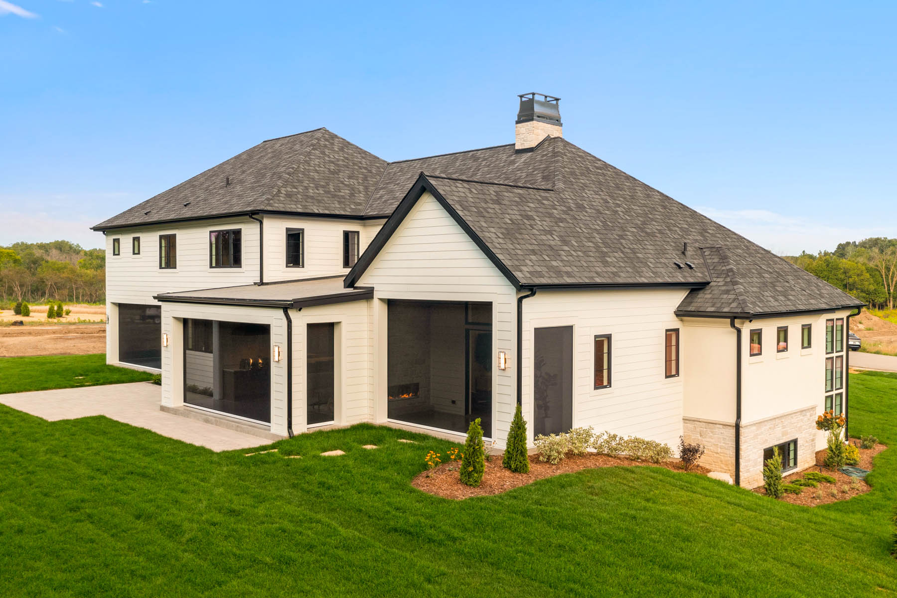 Mediterranean style home with landscaping, black framed windows, three separate screened in back yard patios