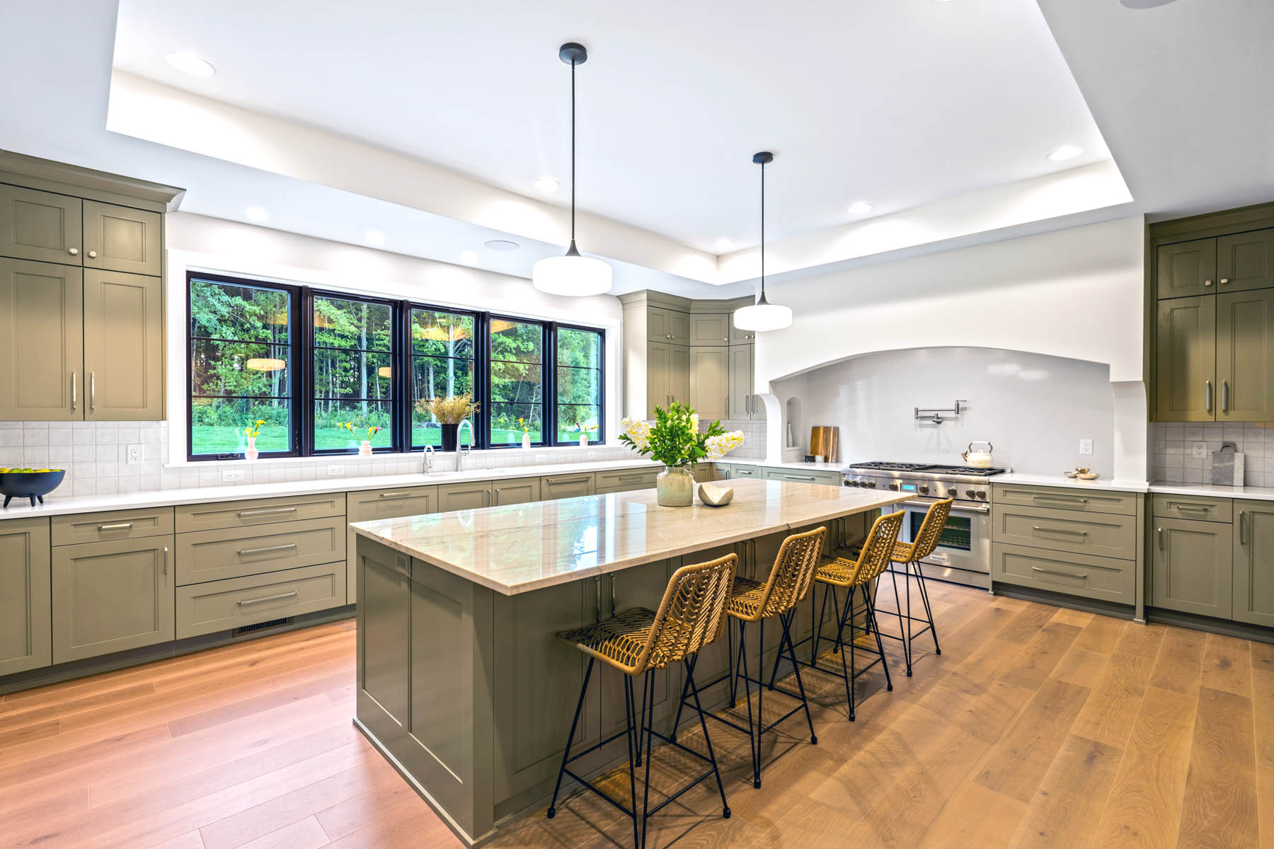 Large kitchen with 9 foot island and plaster curved large range hood