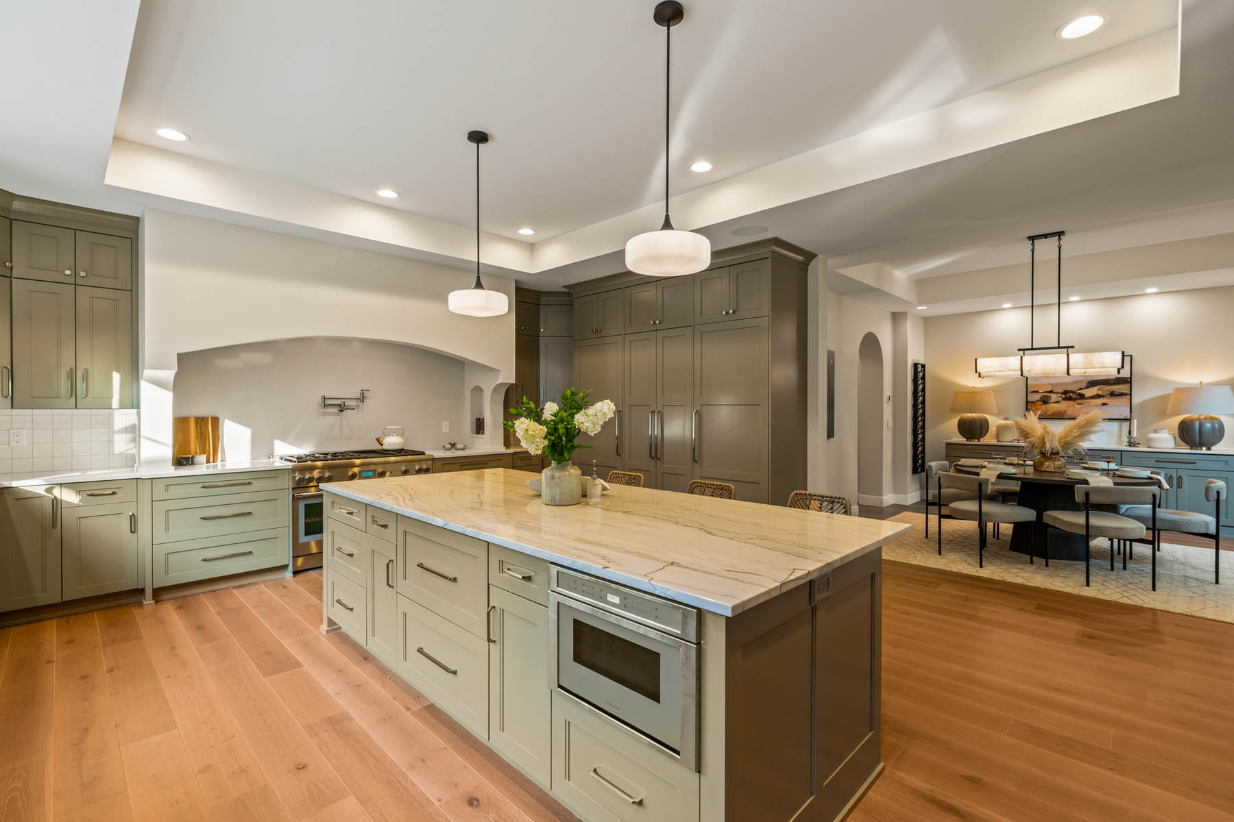 Large kitchen with 9 foot island and plaster curved large range hood