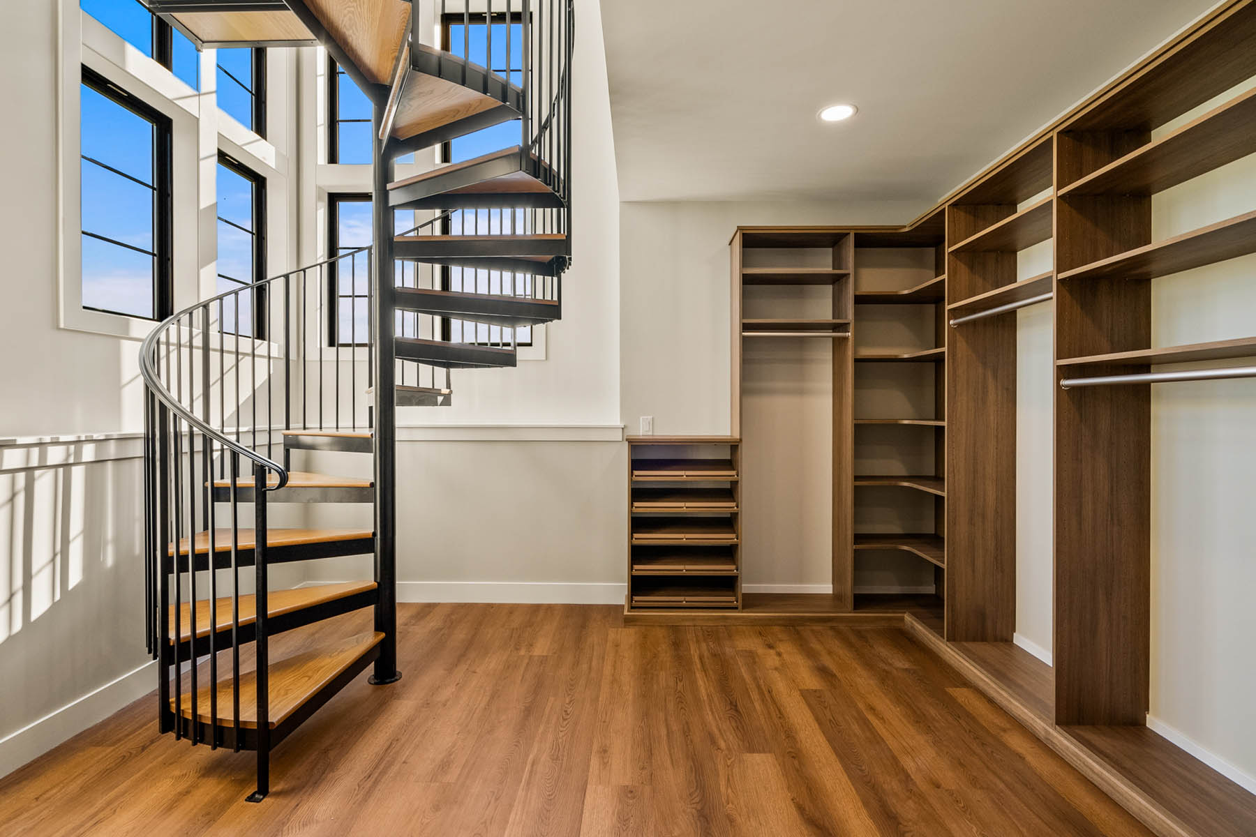 walk in closet with 2 story spiral staircase